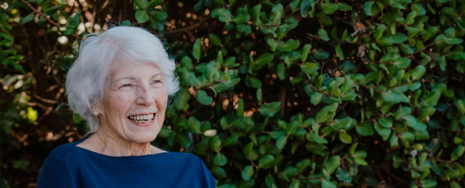 Senior woman smiles out in the gardens