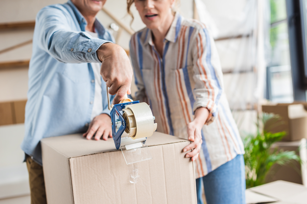 A senior couple packs up a box to donate